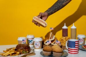 A vibrant display of American food celebrating Independence Day with hot dogs, burgers, and fries.